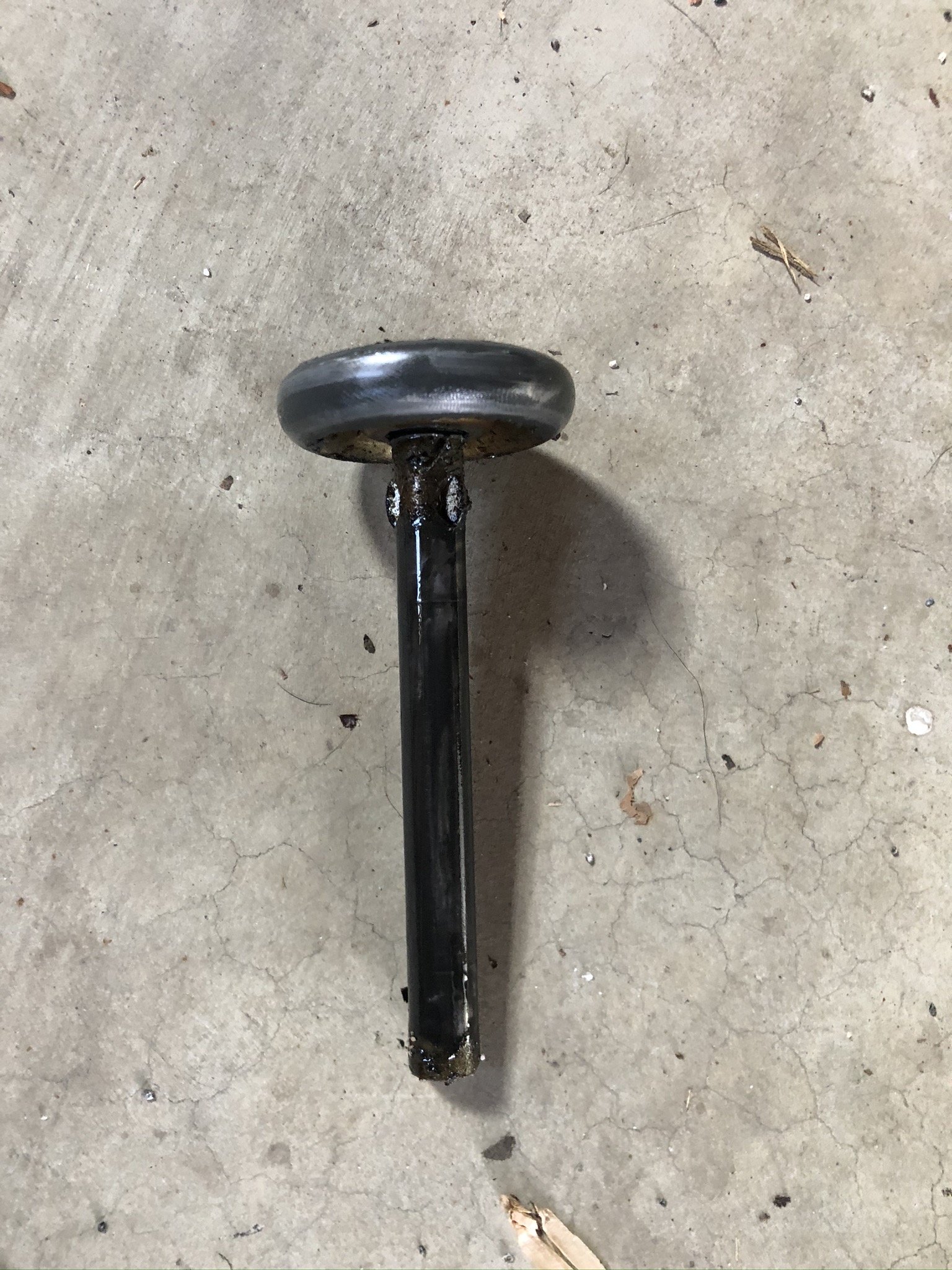 Worn steel roller with a black stem, greasy and dirty