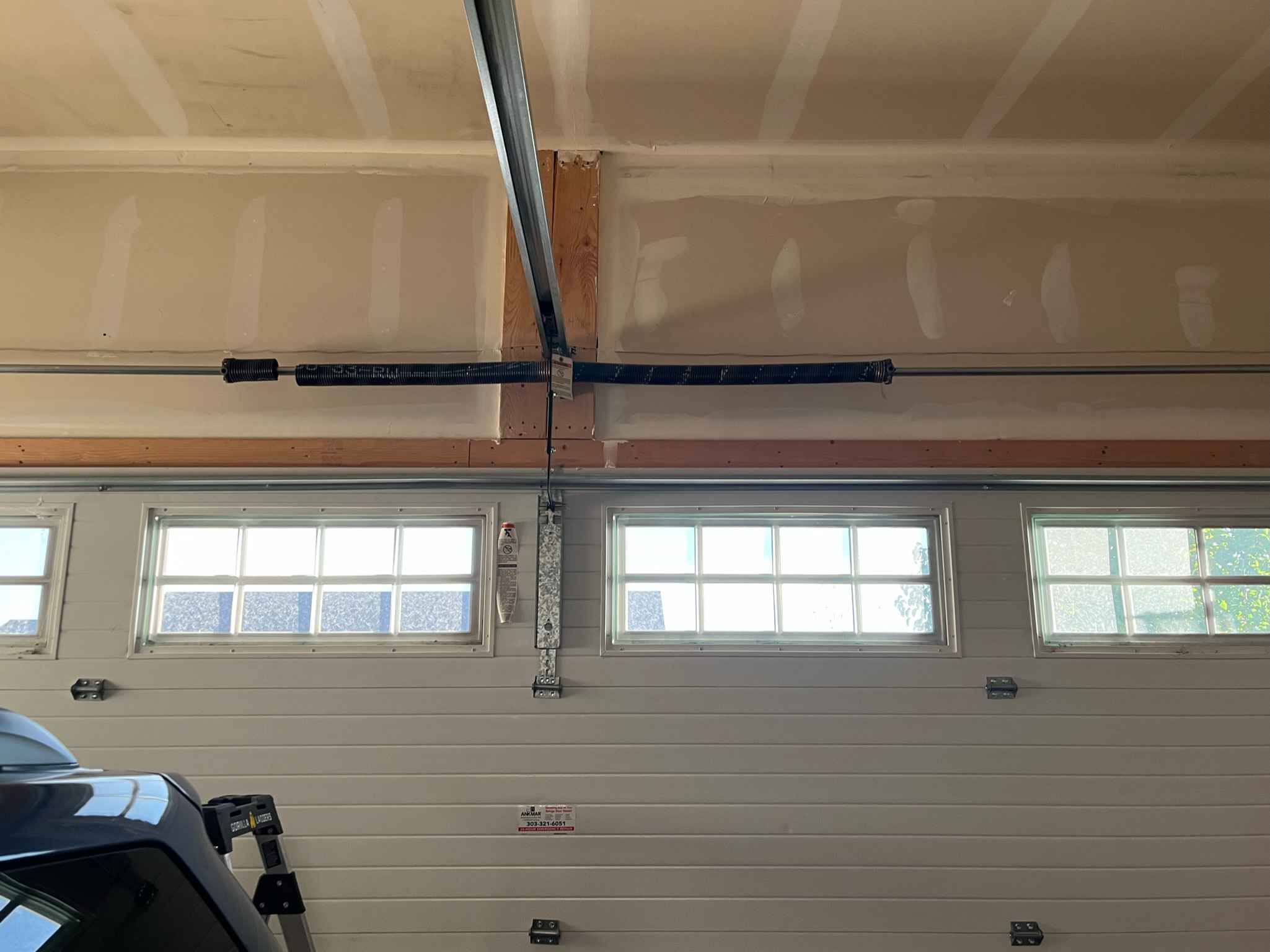 Torsion spring above a closed sectional garage door, seen from inside the garage